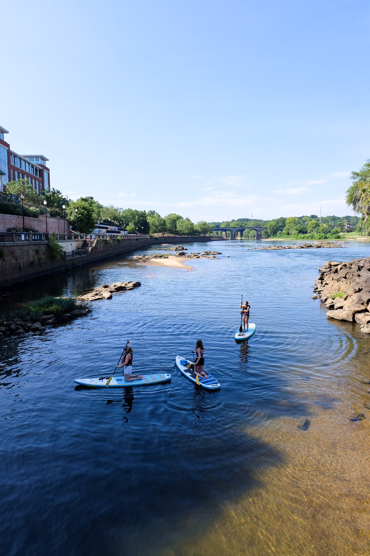 Three women enjoy an afternoon paddleboard session on the Chattahoochee River in Columbus, Georgia.